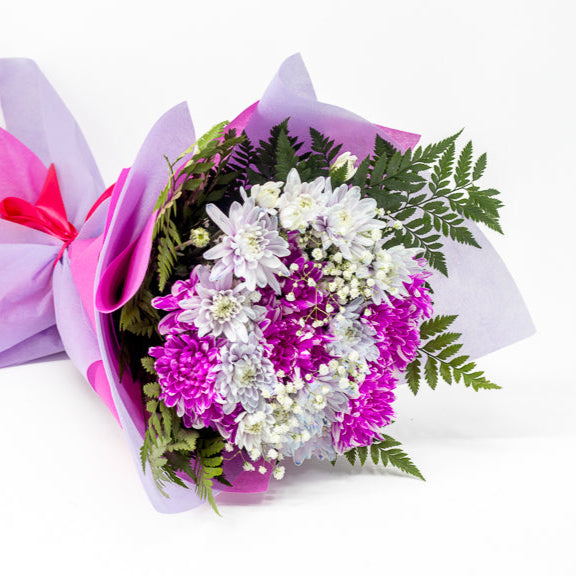 Bouquet of flowers wrapped in purple paper on a white background