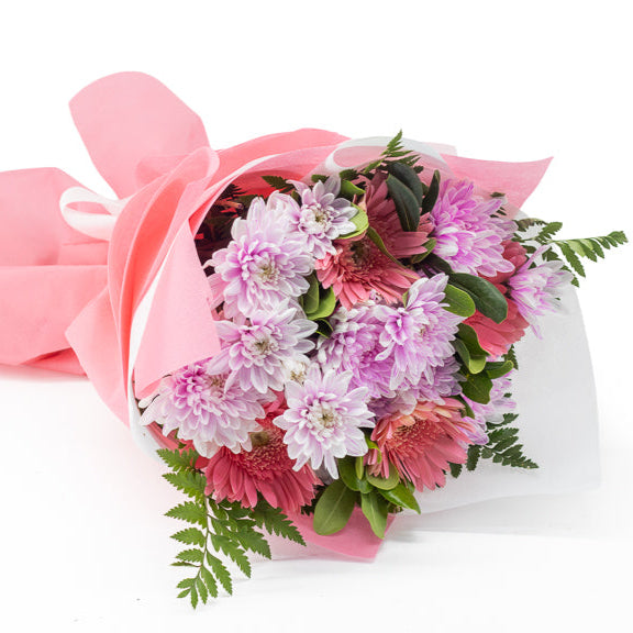 Bouquet of flowers wrapped in pink paper on a white background