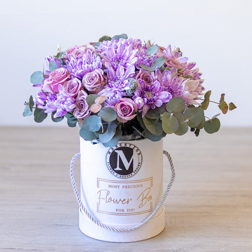 Floral arrangement in a white box labeled 'Most Precious Flower Box' on a light surface.