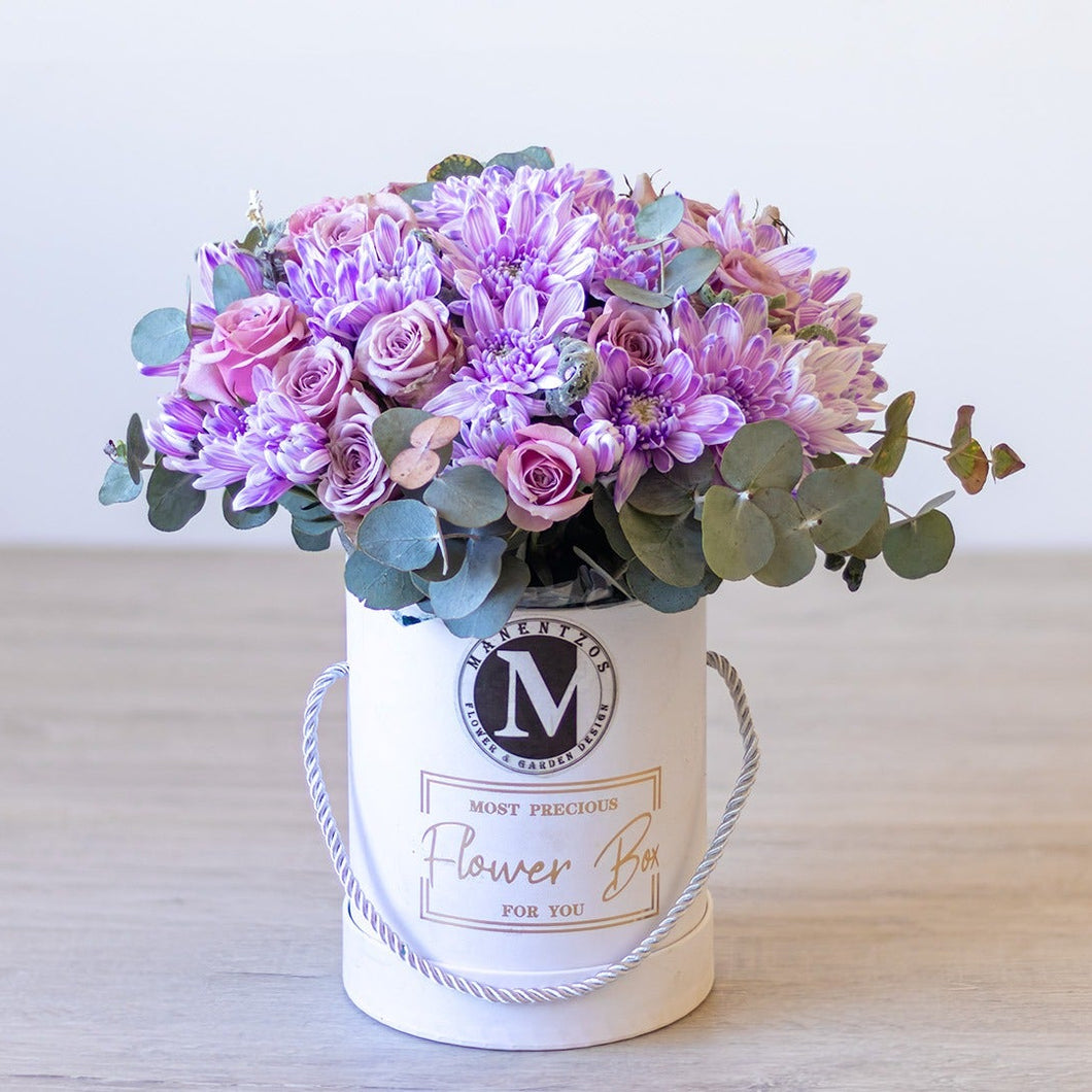 Floral arrangement in a white box labeled 'Most Precious Flower Box' on a light surface.