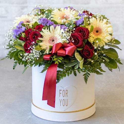 Colorful flower arrangement in a white box with 'For You' text on a light background