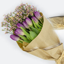Load image into Gallery viewer, Bouquet of purple tulips and greenery wrapped in brown paper on a white background
